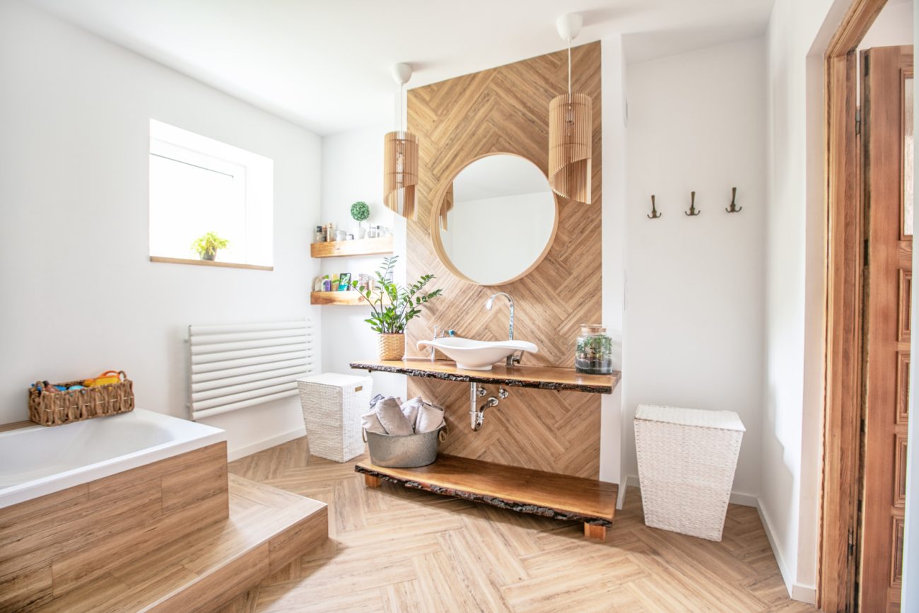 Wooden bathroom interior with beautiful light, plants and white accessories