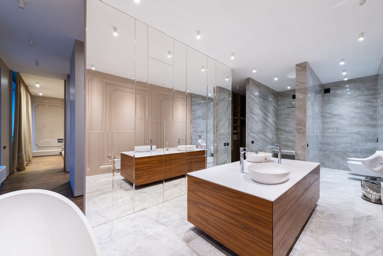 Spacious bathroom with huge mirrors, a central island vanity and open-air shower