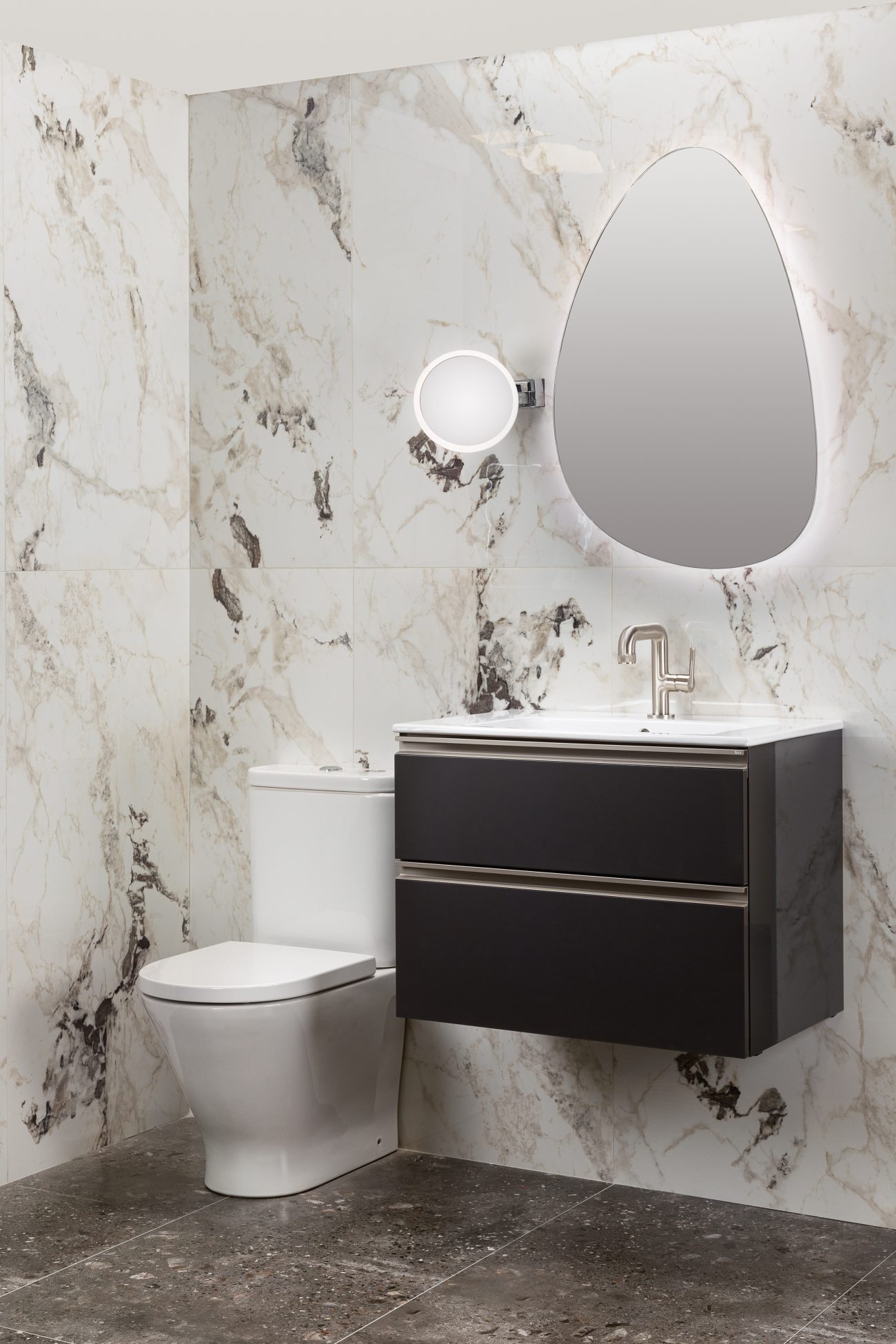 Oval mirror with light frame on an elegant bathroom wall