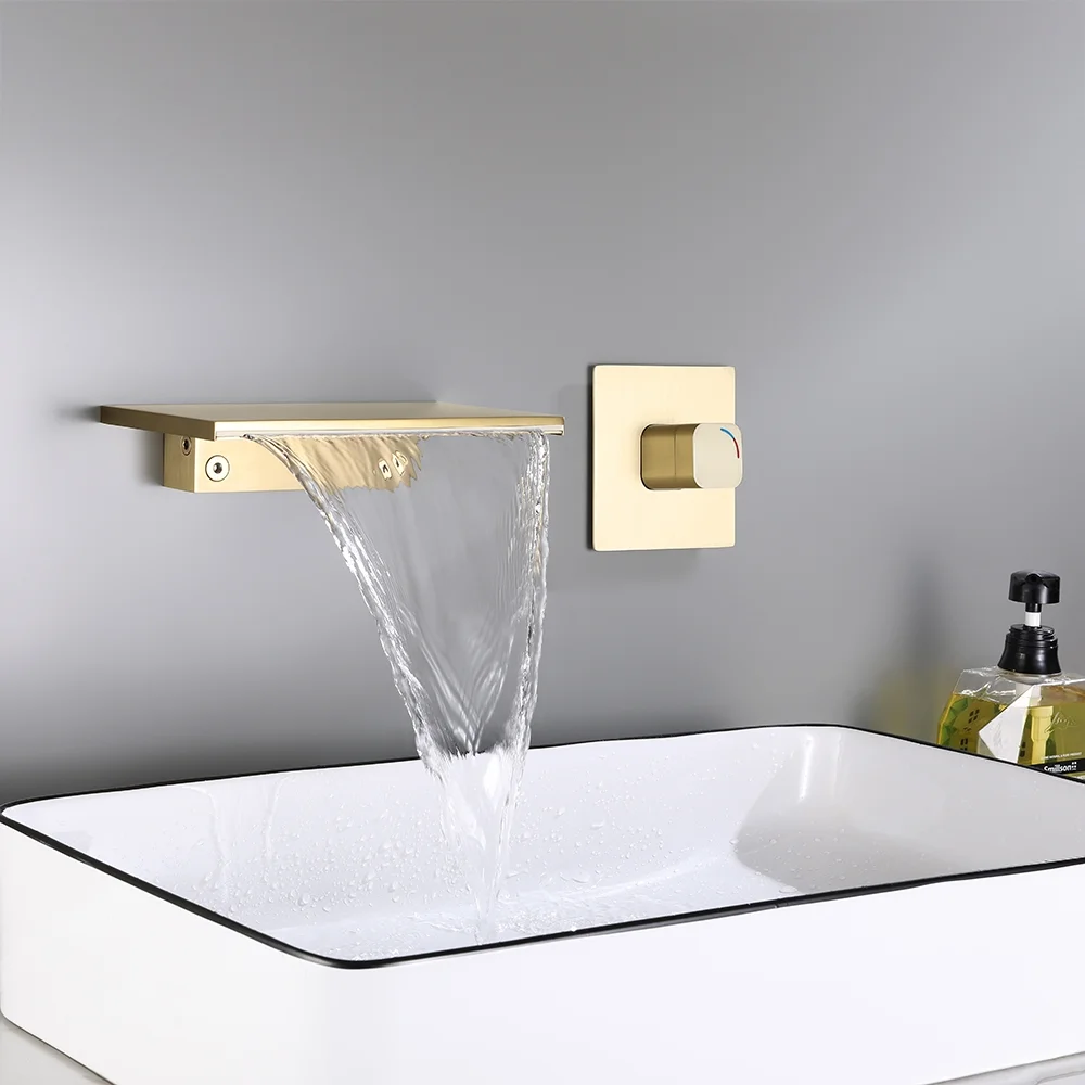 Golden waterfall faucet installed on a bathroom wall