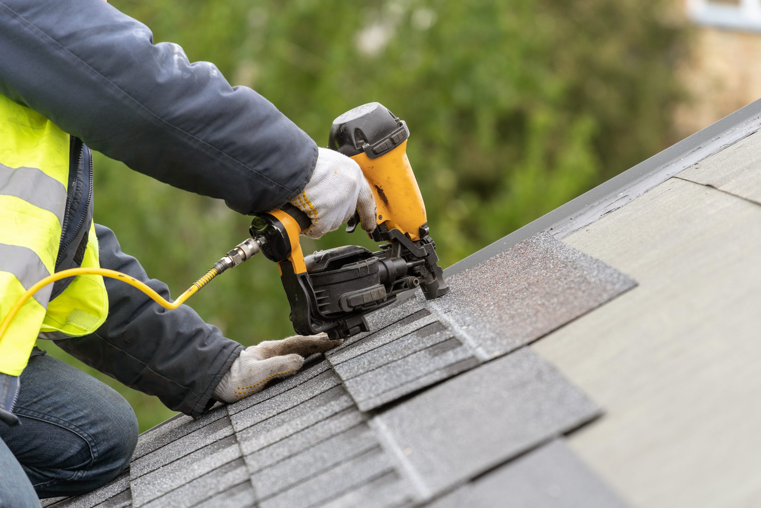 Roofer laying asphalt shingles on a roof