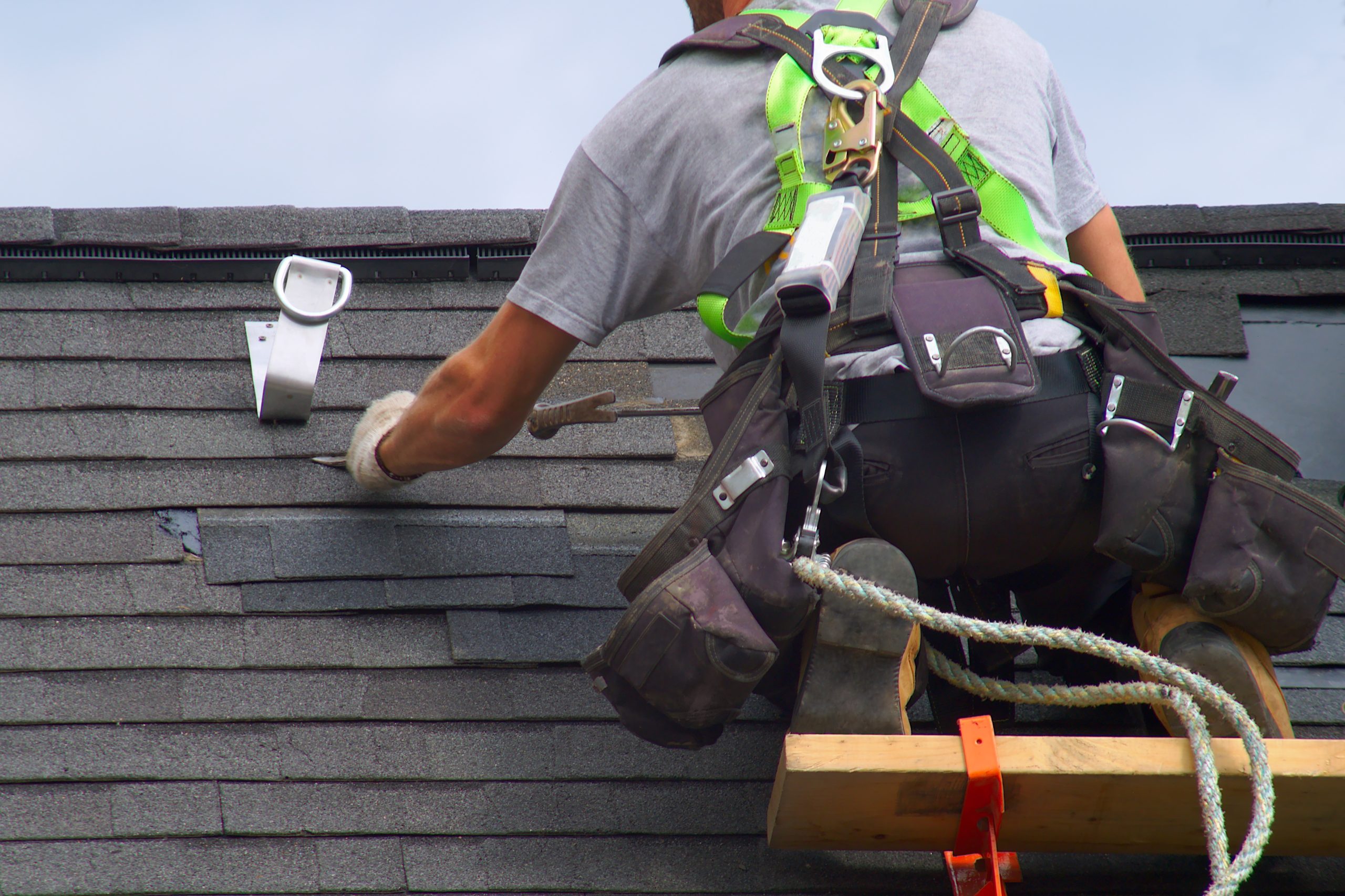 Roofer laying asphalt shingles on a roof 