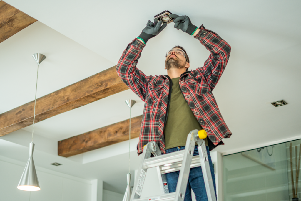 An electrical contractor installs a light fixture in a farmhouse-style home with HomeExpress service.